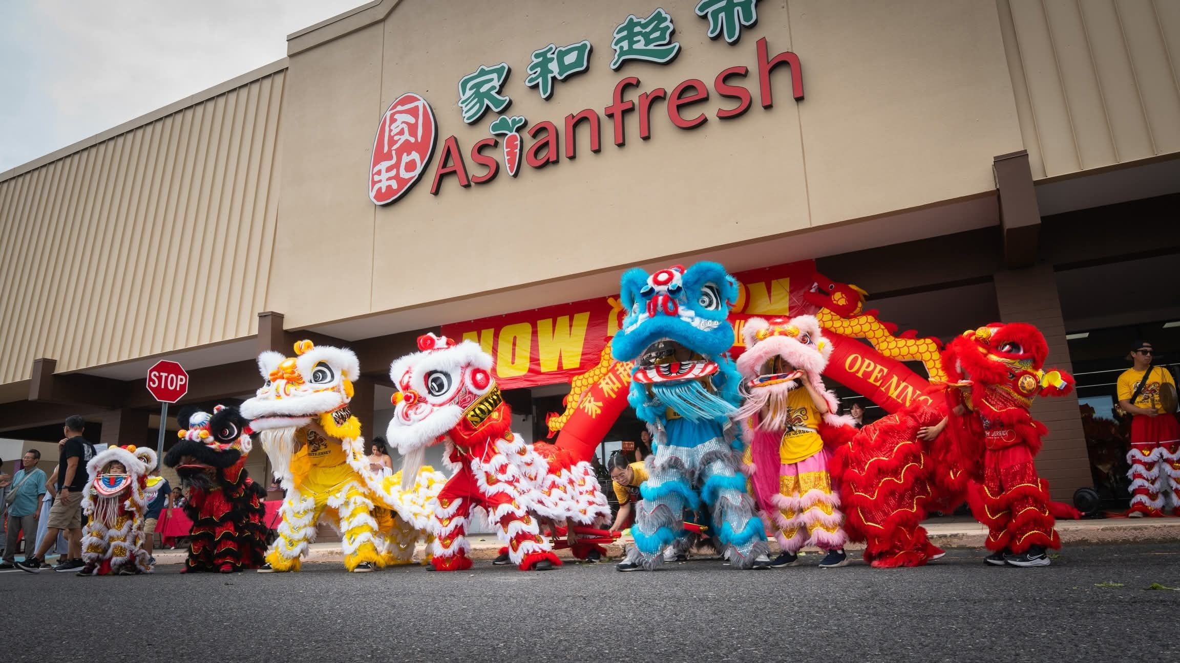 A line of lions performing in front of a newly opened Asian supermarket