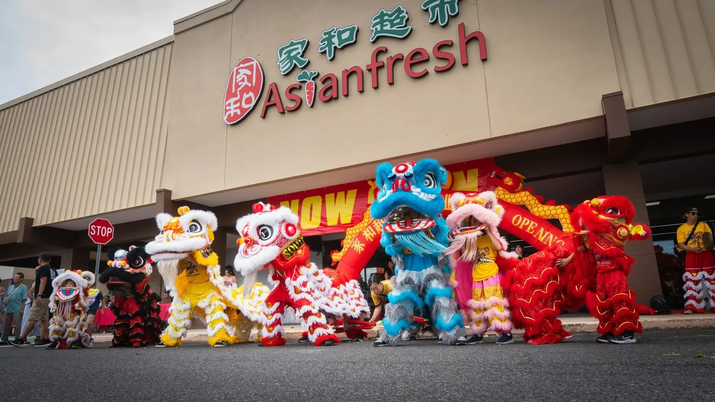 A line of lions performing in front of a newly opened Asian supermarket