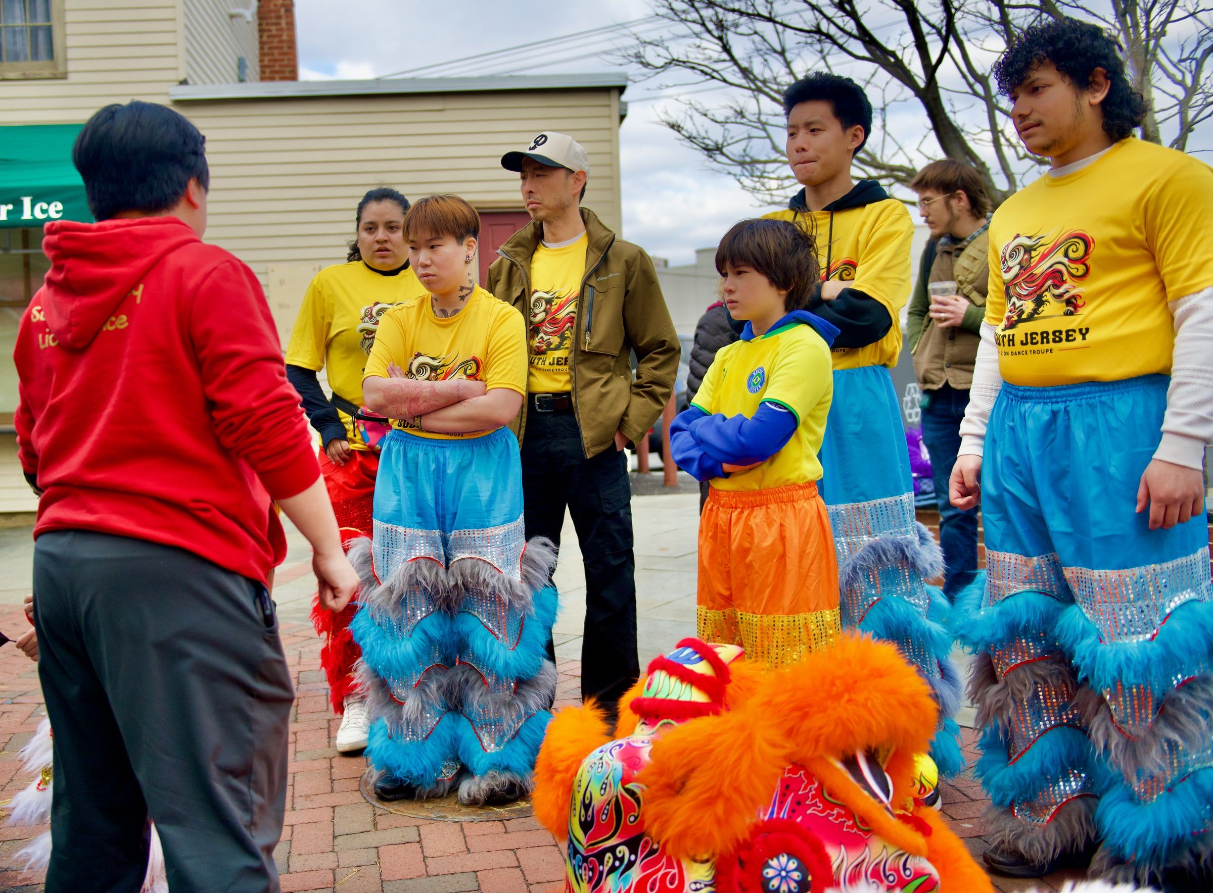 Performers in lion costume trousers listening to instructions before a show