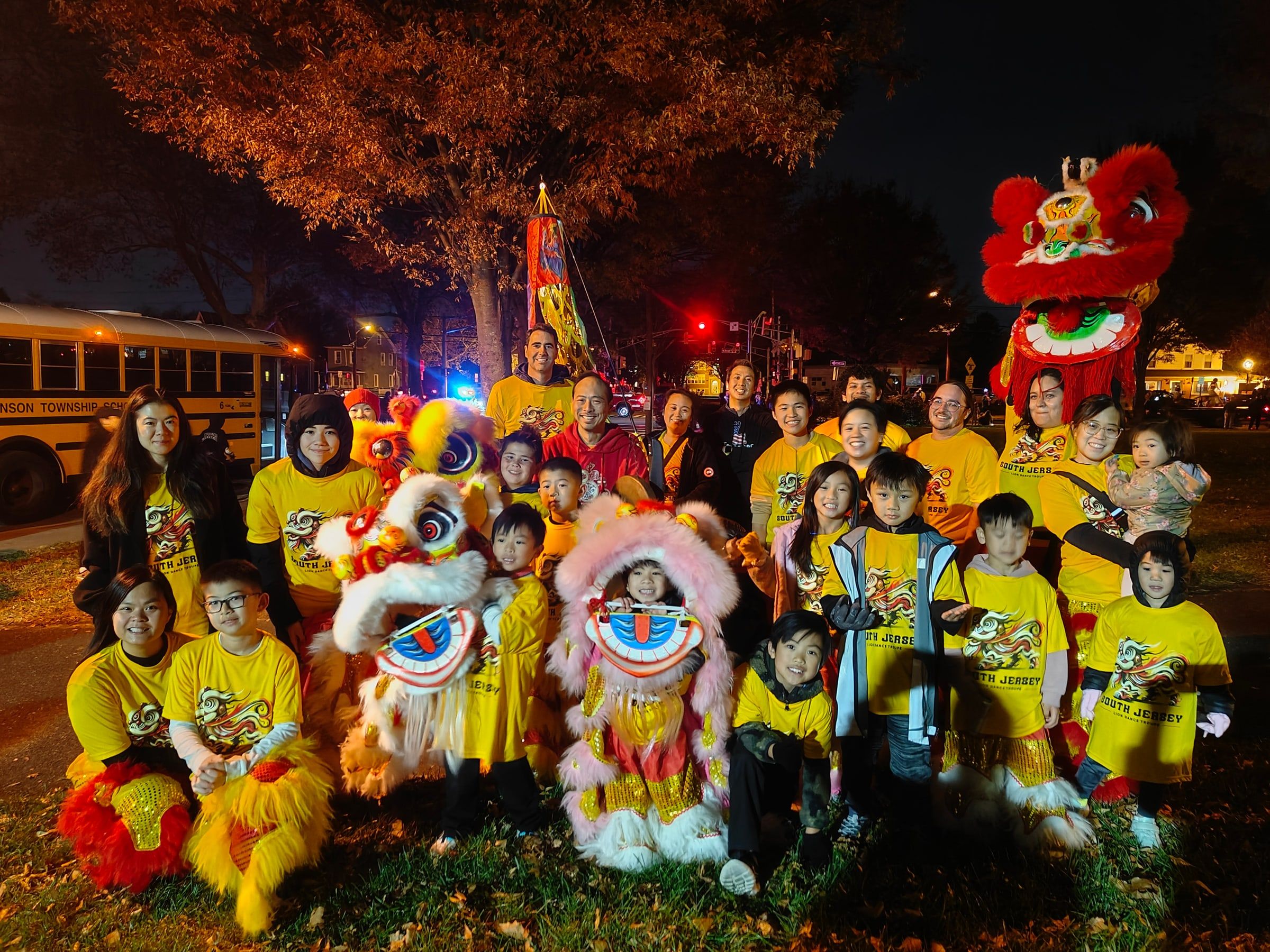 The troupe and their lions gathered for a group photo at an evening event