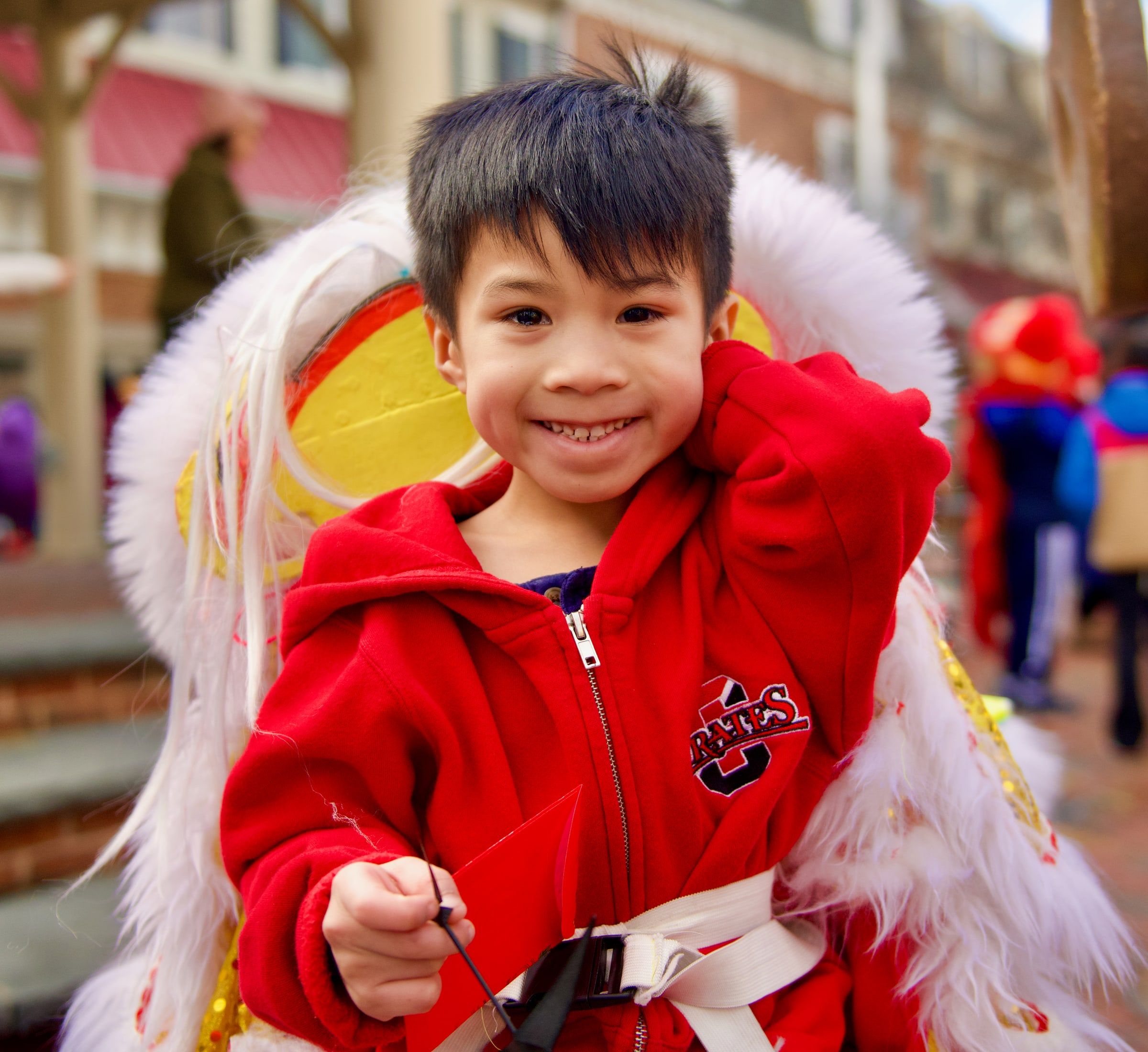 A smiling young performer holding up his lion head